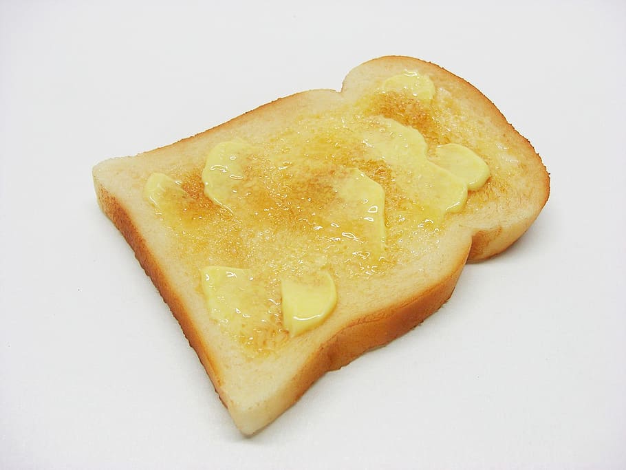 close-up photo of sliced bread with butter on white surface HD wallpaper