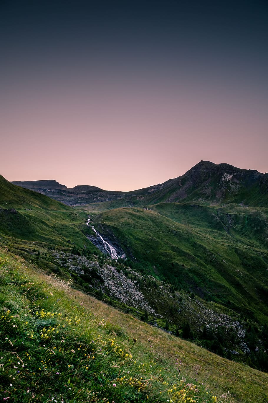 landscape photography of mountain range with river cascading, mountain range with green grass HD wallpaper