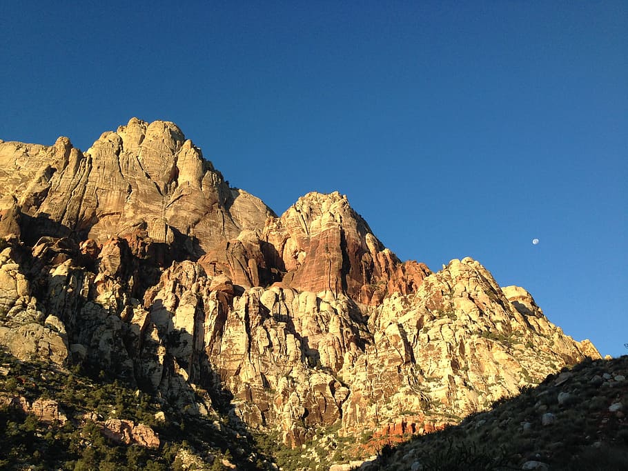 brown rock mountain during daytime, brown mountain under moon during daylight HD wallpaper