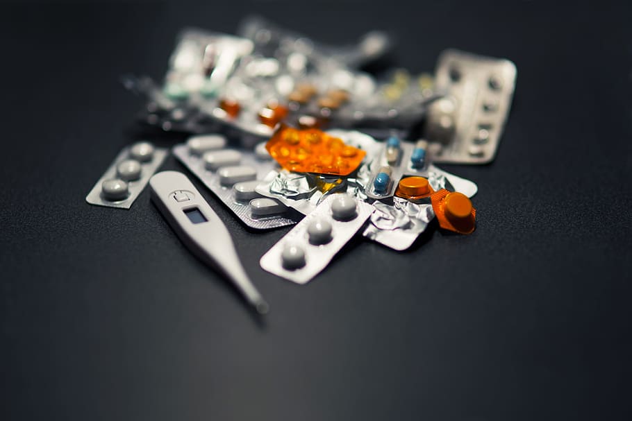 assorted medication pills and digital thermometer at black surface HD wallpaper