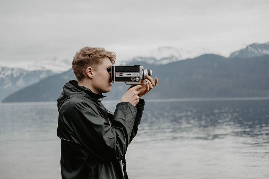 man taking video near body of water, man using digital telescope near body of water during daytime HD wallpaper