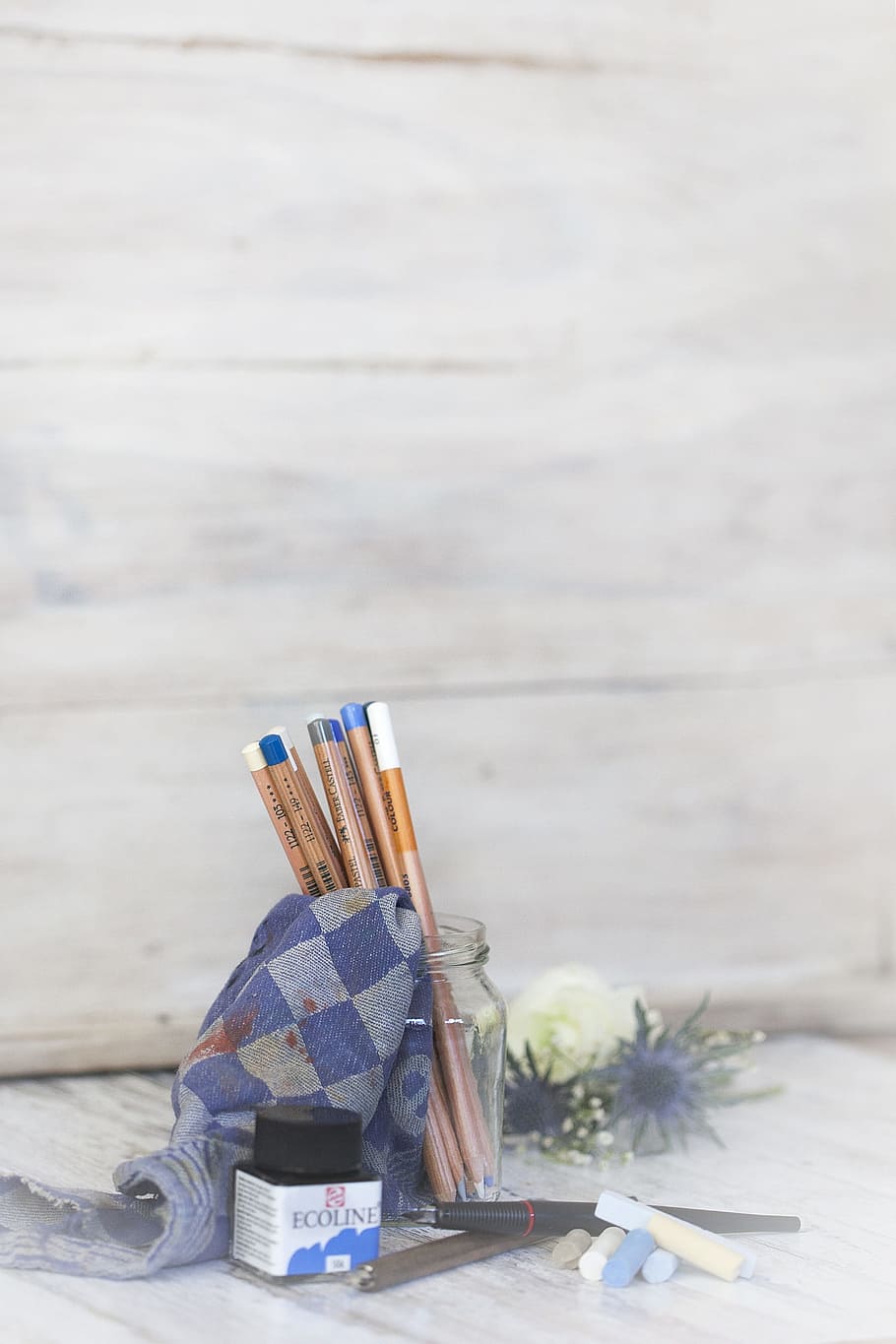 pencils in round clear glass jar beside blue and gray textile on white surface HD wallpaper