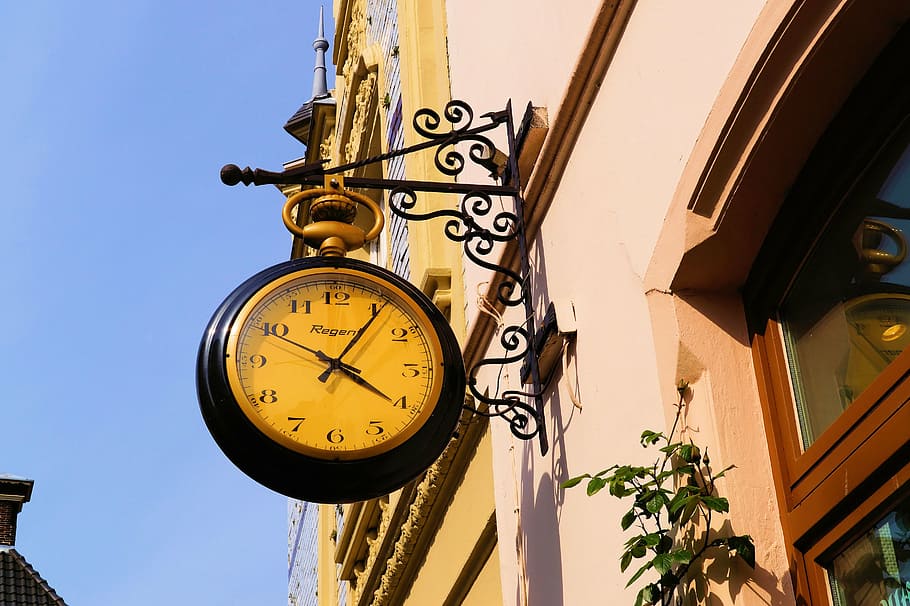 round black and beige analog clock hanging on black metal rack under blue sky displaying 4:06 HD wallpaper