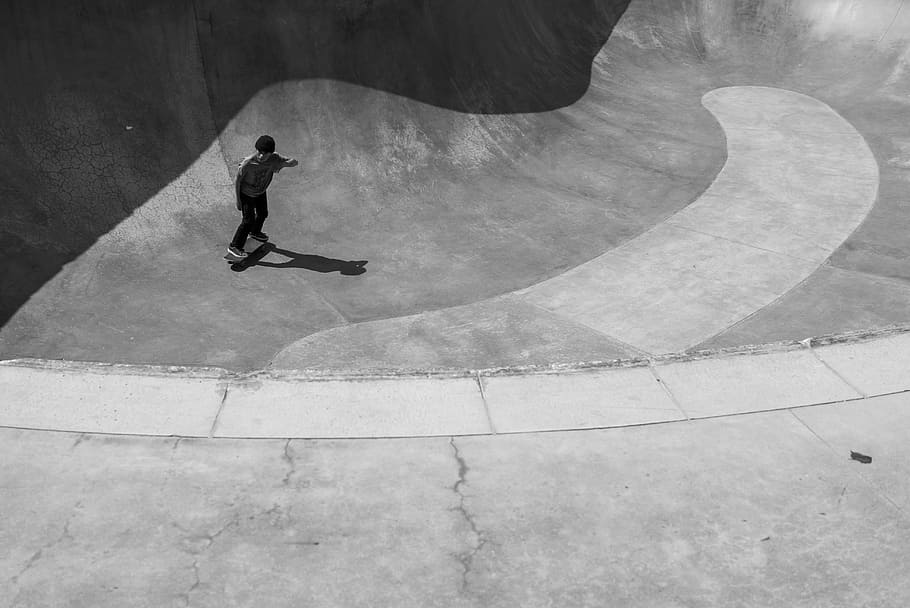 grayscale photography of man on skateboard, person riding on skateboard