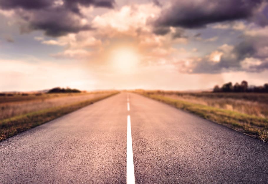 empty concrete pavement between green grass, road, sunset, horizon HD wallpaper