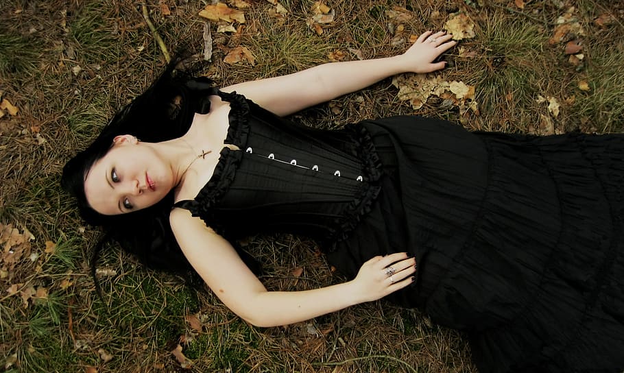 woman in black sleeveless dress lying on green grass field, female