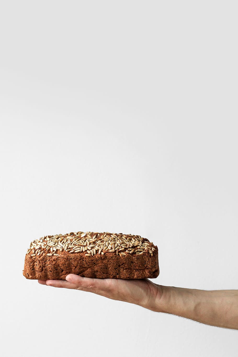 Home-baked bread, person holding baked bread, cake, seeds, hand HD wallpaper