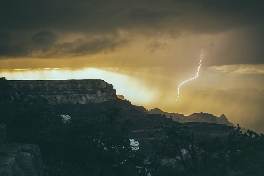 lighting strikes down in sandstorm, silhouette photography of lightning on rocky mountains HD wallpaper