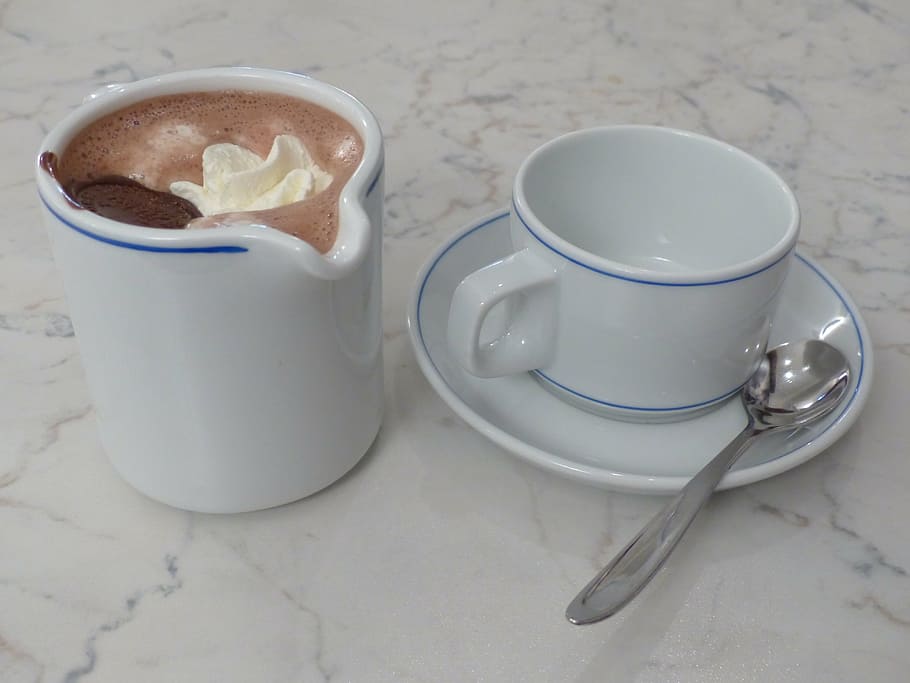 white ceramic mug with chocolate drink beside coffee mug with spoon on white surface HD wallpaper