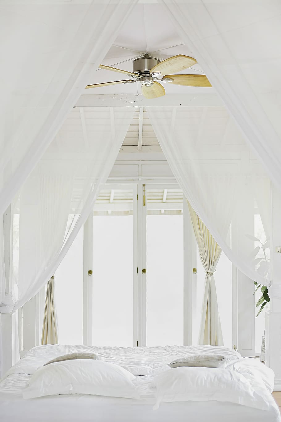 bed sheet near glass window, white bedroom, ceiling, fan, door