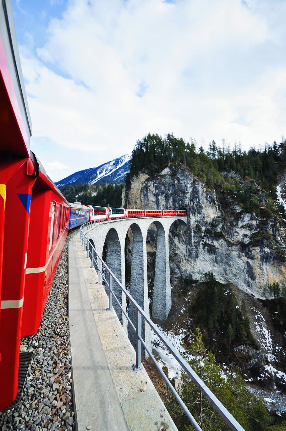 scenery of mountain and bridge, red and white train entering tunnel under blue cloudy skies HD wallpaper