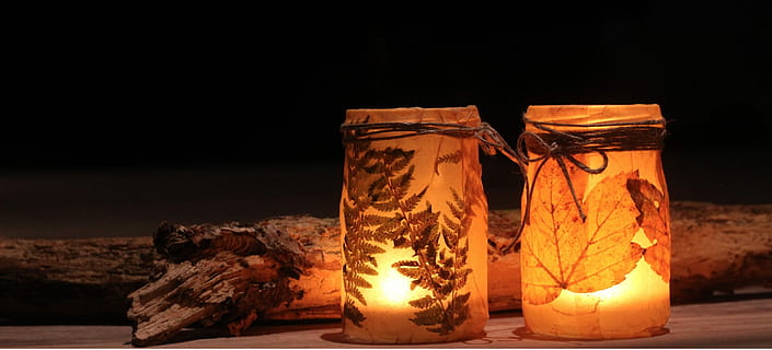 two candles in brown decorative jars beside firewood, Halloween HD wallpaper