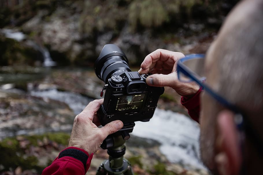 person wearing red sweater holding camera, nature, man, people HD wallpaper