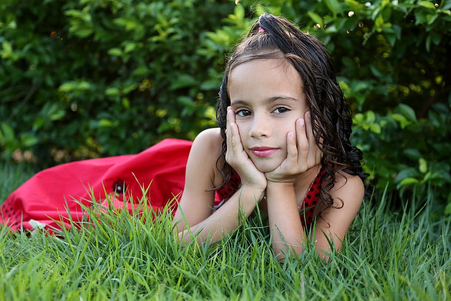 girl in red dress on green grass, girl looking, girl in the garden