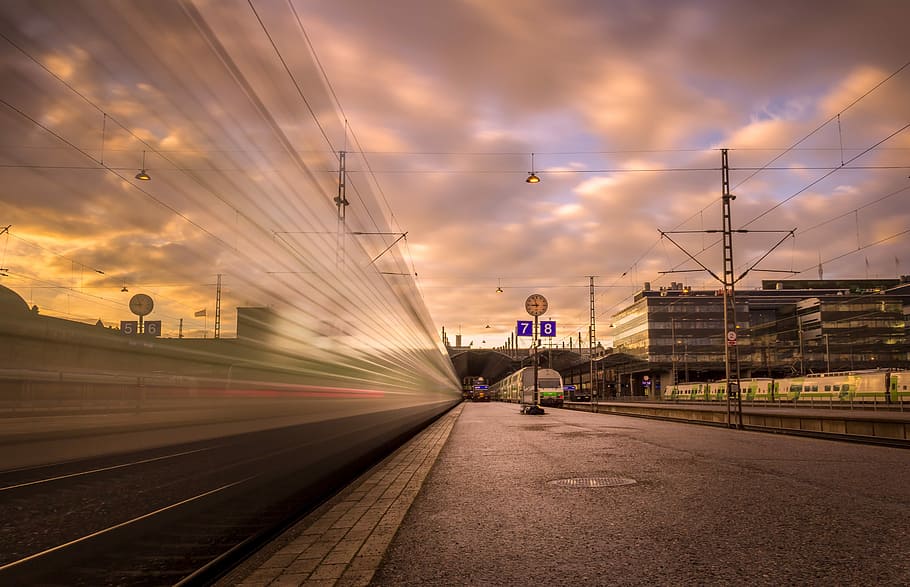 photo of train near station, timelapse photography of train near utility post