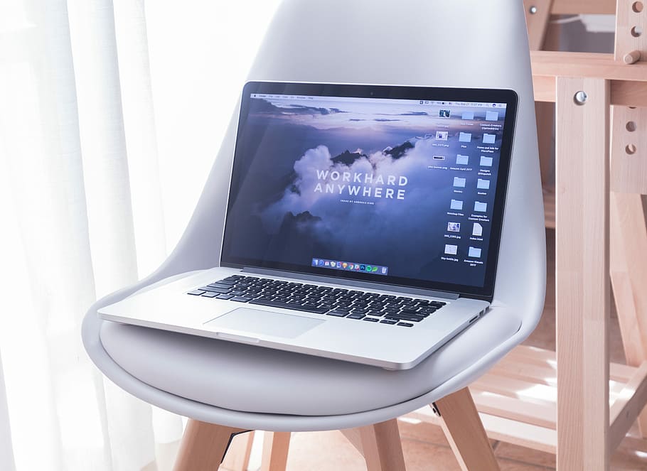 MacBook Pro on white padded chair, MacBook Pro on top of chair HD wallpaper