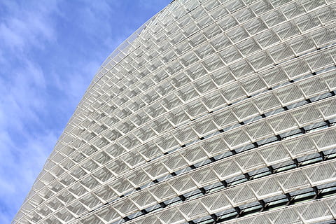 low-angle photography of gray building under white clouds and blue sky at daytime HD wallpaper