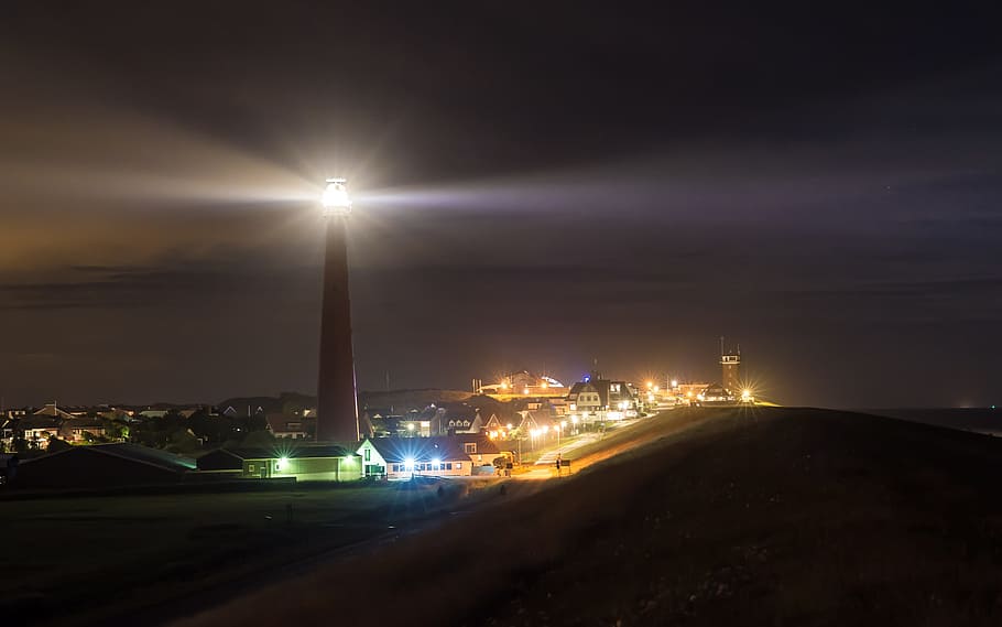 turned on lighthouse, night, lights, city, sea, lake, north sea HD wallpaper