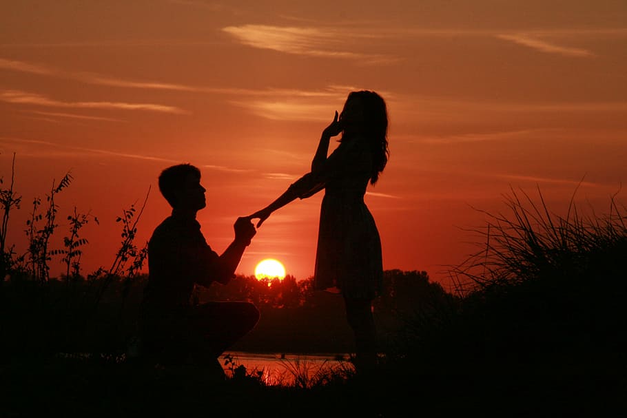 silhouette of man holding ring to woman, couple, love, sunset