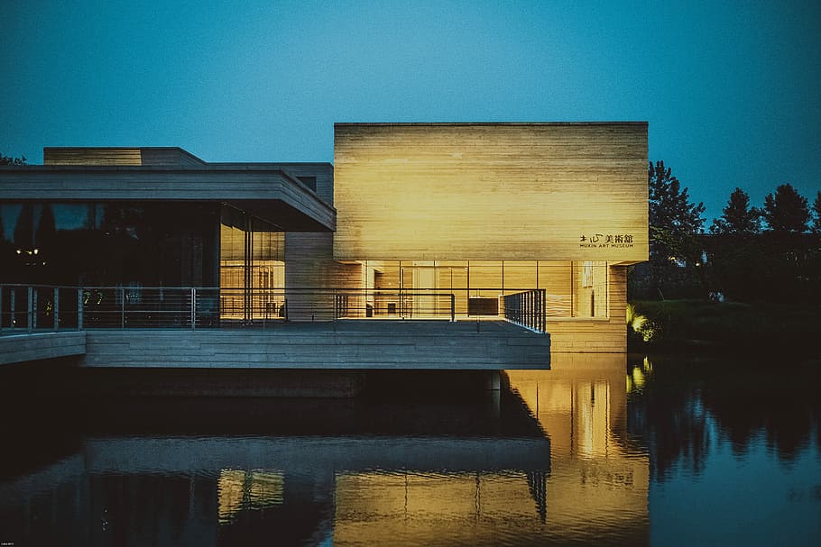 brown building beside body of water at nighttime, lighted house on body of water, HD wallpaper