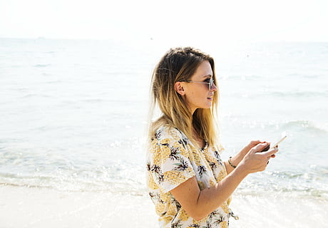 woman wearing white and multi-colored floral shirt standing near the shore HD wallpaper
