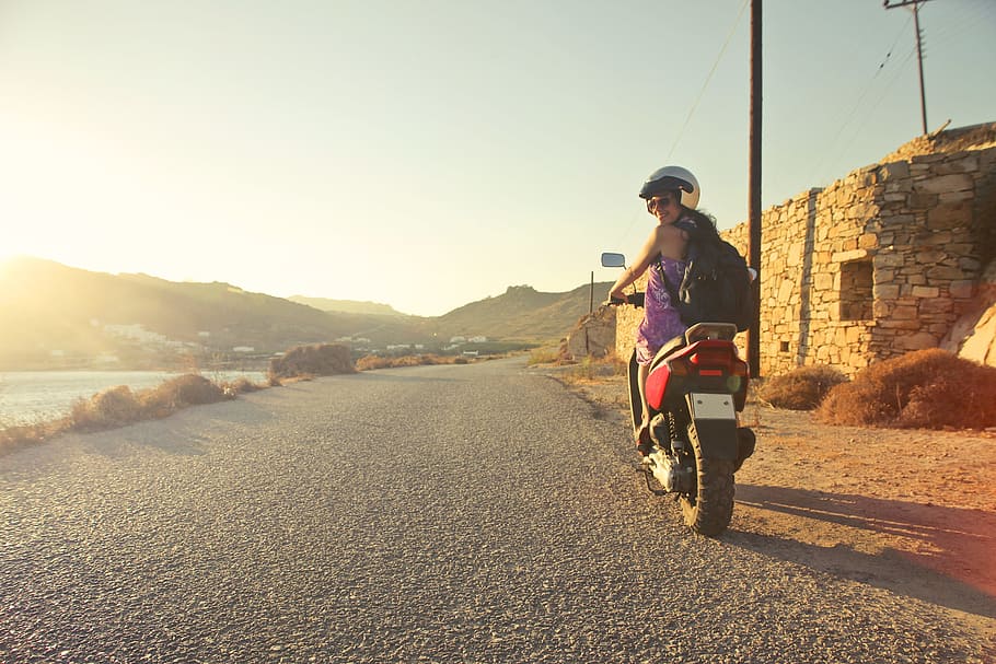 Woman Riding Motor Scooter Travelling on Asphalt Road during Sunrise HD wallpaper