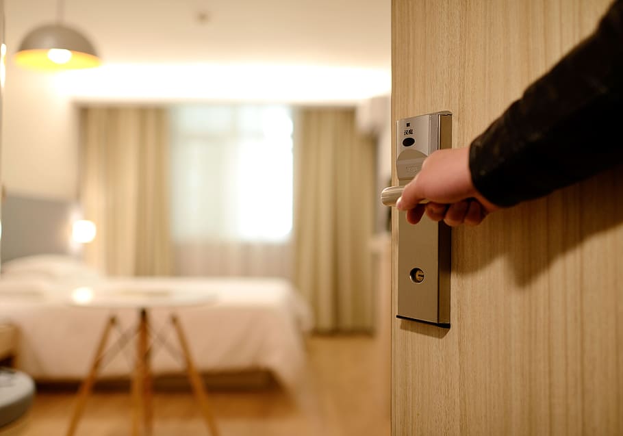 person in black top opening a door to an empty room, hotel, guest room
