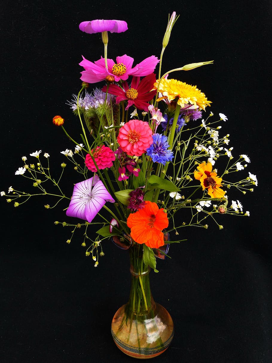 red-blue-and-yellow petaled flowers in amber glass vase, birthday bouquet
