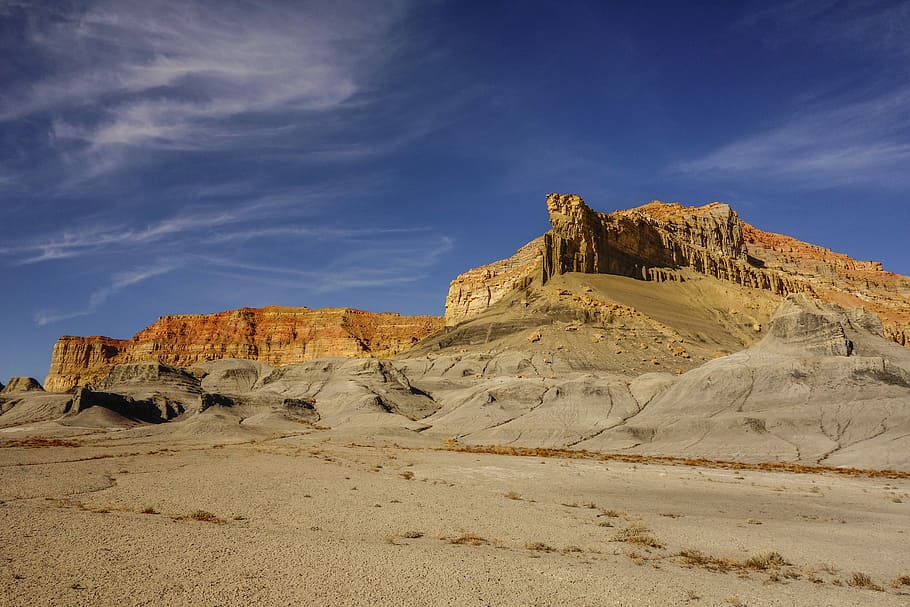 brown cliff near desert at daytime, dessert with mountains during daytime HD wallpaper