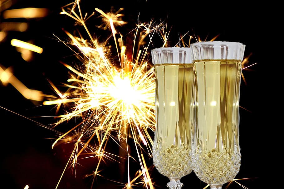 two glasses of yellow liquid and sparklers, new year's eve, champagne glasses