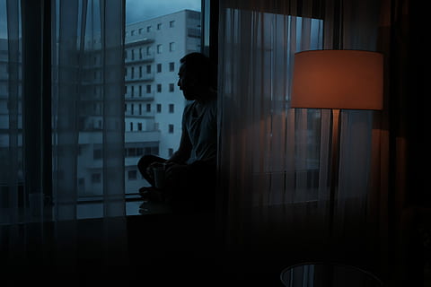 HD wallpaper: Man sitting on a window sill, looking out at night