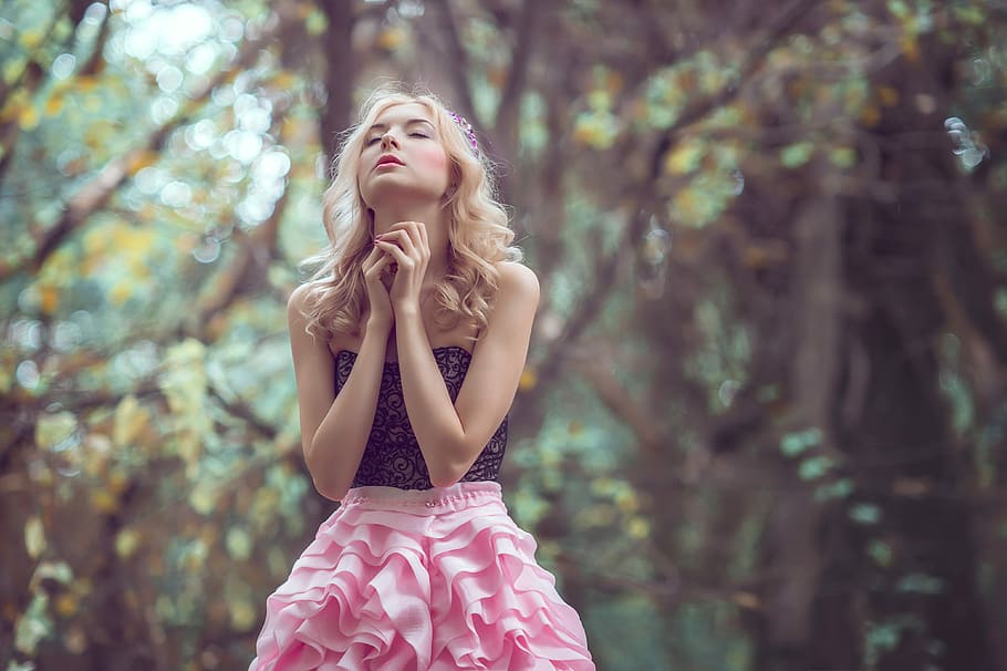selective focus of woman meditating wearing black and white strapless dress beside trees during daytime HD wallpaper