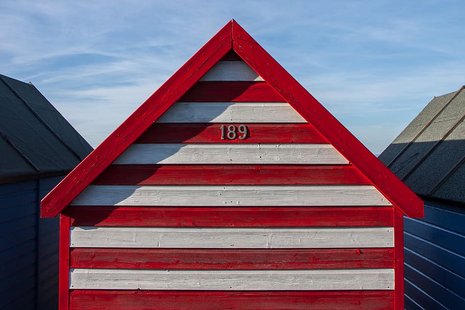 A red and white-striped beach hut sits on the Kent Coast in Southern England HD wallpaper