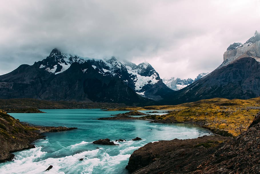 body of water with snow-capped mountain at distance, highland HD wallpaper