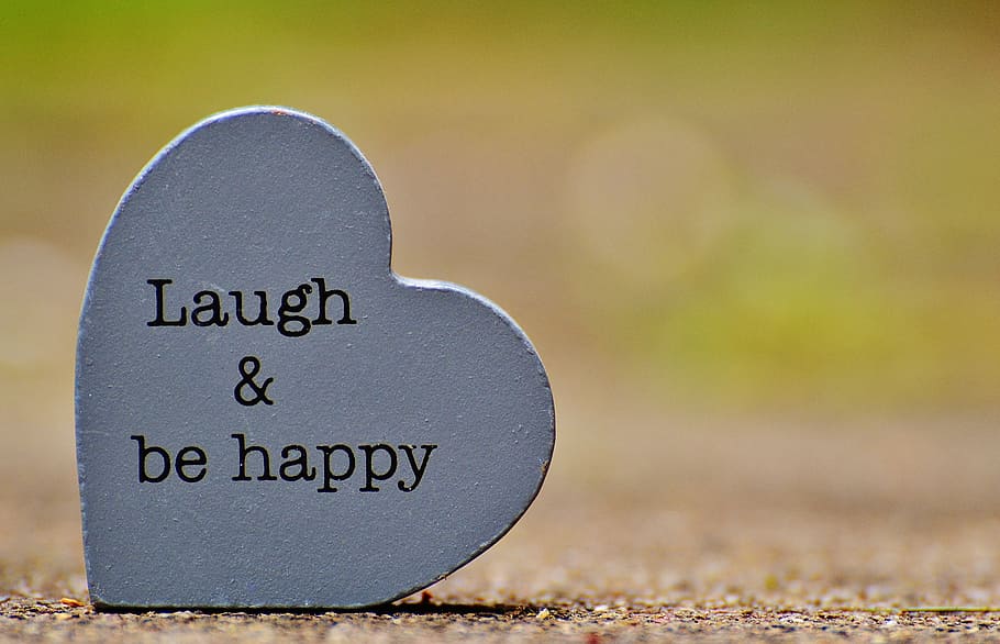 Laugh & be happy text on heart-shaped gray concrete decor, cheerful