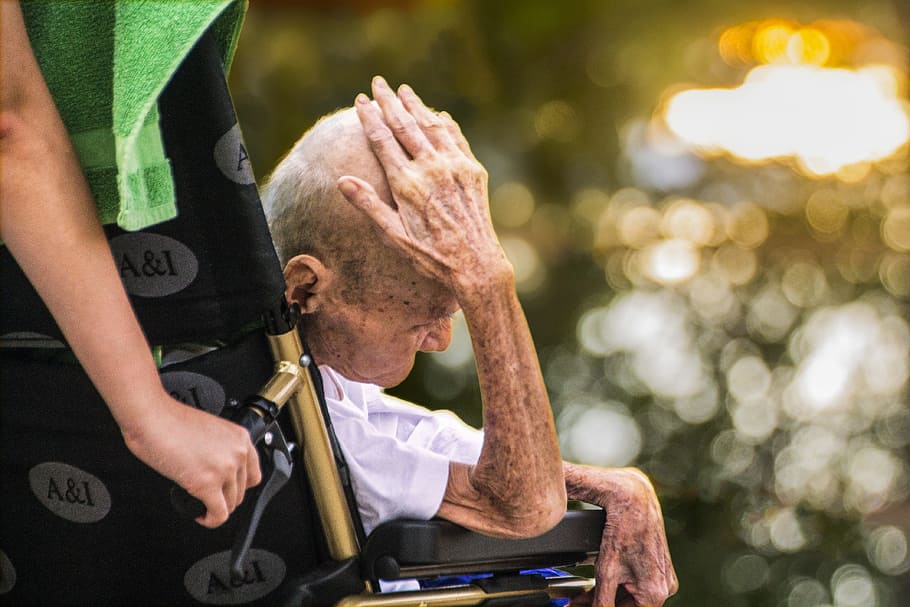 selective focus photography of man sitting on wheelchair, hospice