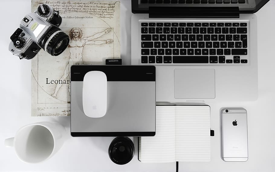 white Apple Magic Mouse, gray trackpad, gray SLR camera, space gray iPhone 6s, and MacBook Pro on table, gray and black DSLR camera near Apple Magic Mouse and MacBook Pro HD wallpaper