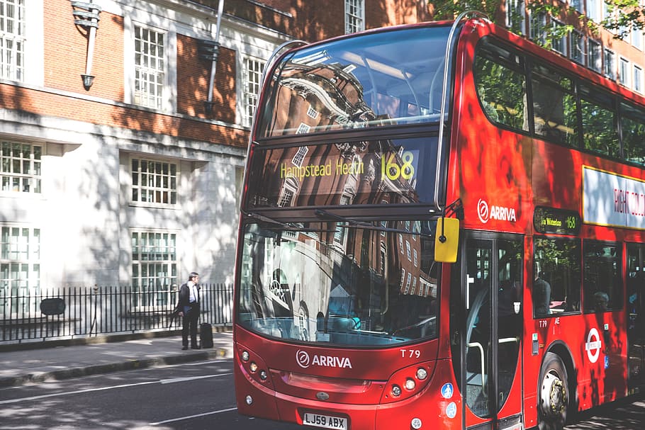 A classic red London bus sits in dappled sunlight on a road in Central London, image captured with a Canon DSLR, HD wallpaper
