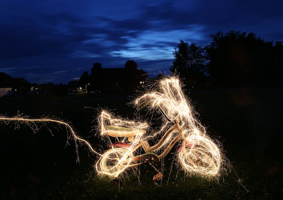 timelapse photograph of bicycle string lights, bike decorated with string lights parkin on garden during nighttime HD wallpaper