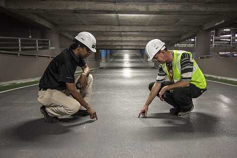 two men pointing grey floor inside underground, onsite, man HD wallpaper