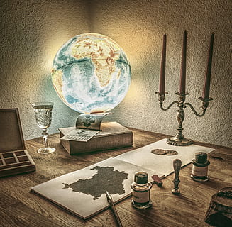 lighted desk glove on table near note pad and clear glass on table painting HD wallpaper