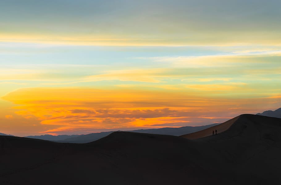silhouette of mountain during sunset, silhouette of two person standing on mountain HD wallpaper
