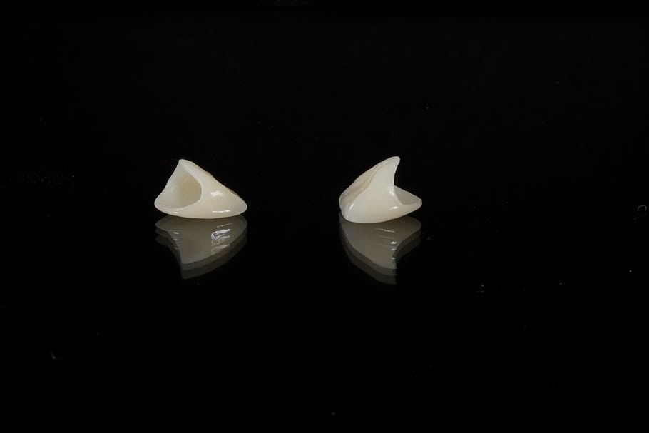 two white tools, dental, porcelain tooth, wax, black background