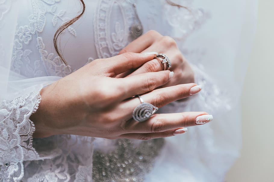 silver-colored ring, person holding silver-colored ring on hand