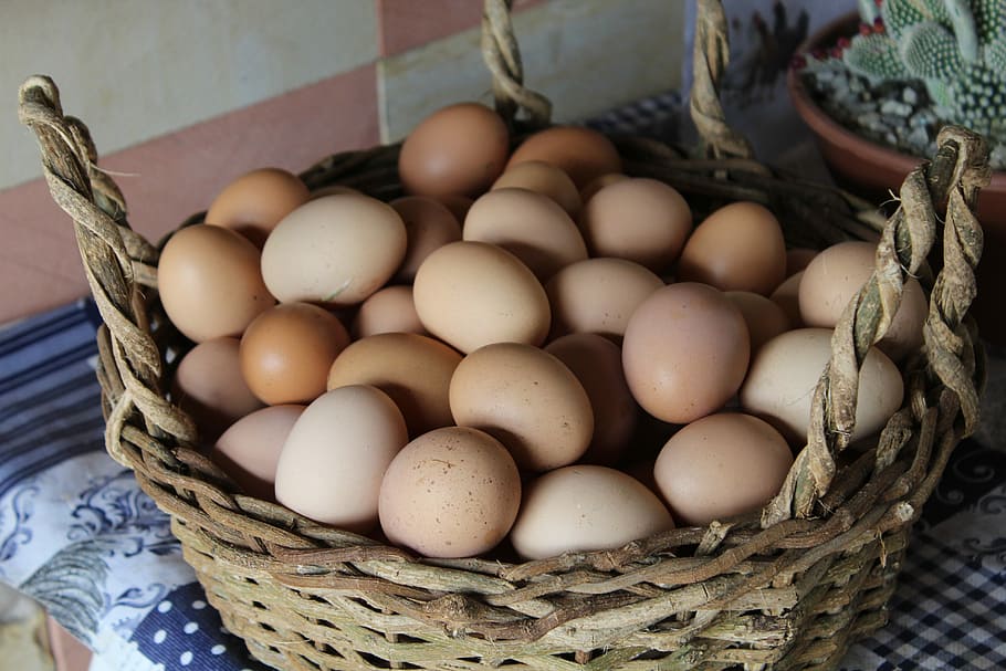 eggs in brown wicker basket, chicken eggs on basket, kitchen