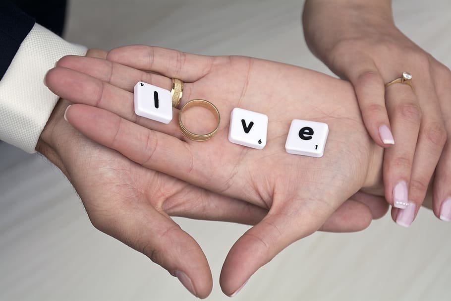 two person's hand holding gold-colored ring, hands, love, marriage