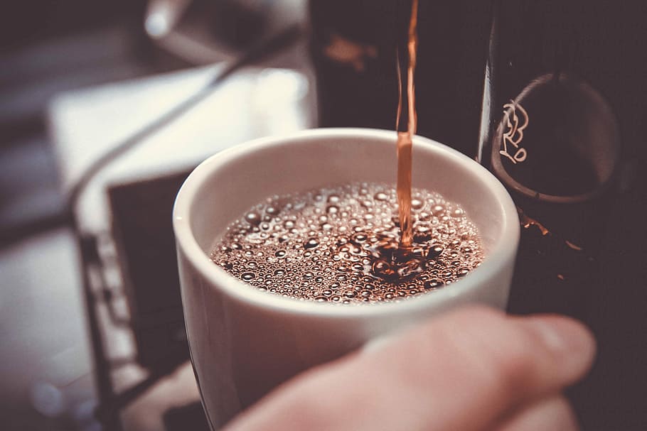 person holding white cup pouring coffee, selective focus photo of coffee on cup HD wallpaper
