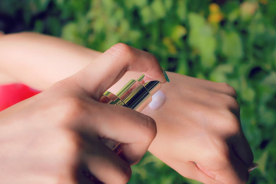 close-up of a person's hand spraying lotion on her arm, human Hand HD wallpaper