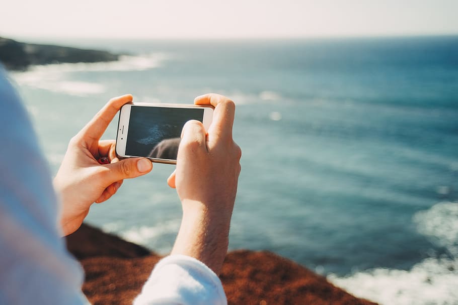 person holding iPhone with black case, phone camera, scenery HD wallpaper