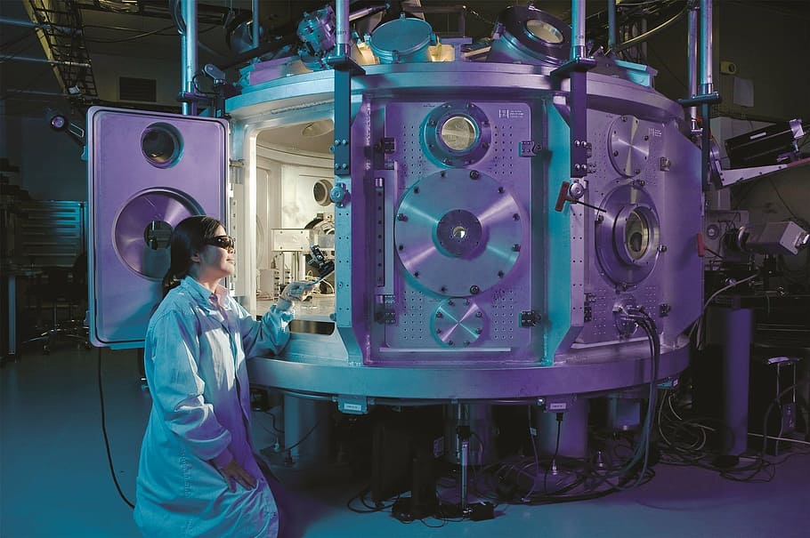 photograph of person near machine, scientific, equipment, physicist
